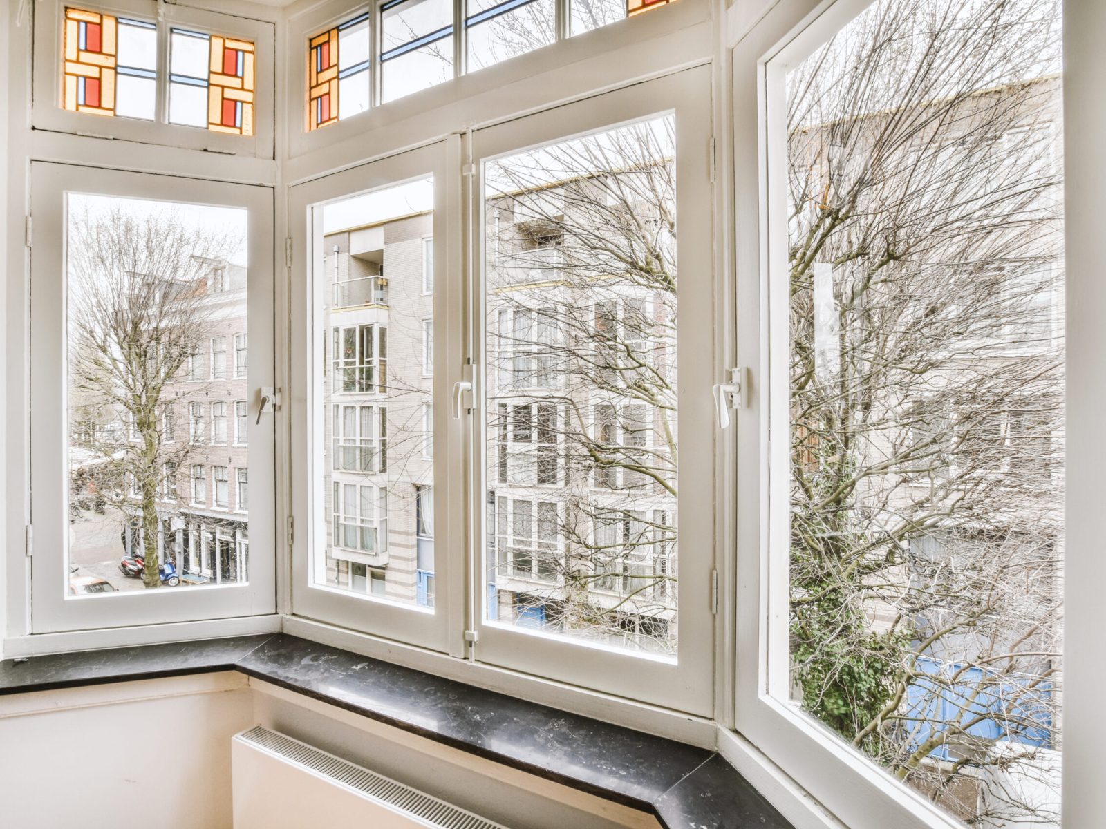 Plastic window and radiator on white wall in empty light room at home